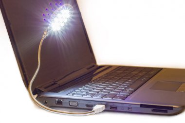 Luminous LED USB lamp connected to notebook  clipart