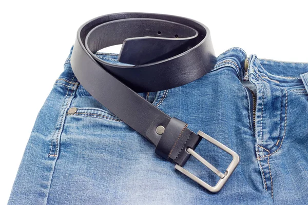 Zwarte leren riem ligt op een spijkerbroek — Stockfoto