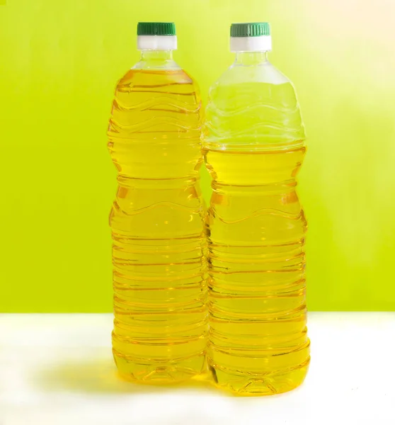 Duas garrafas de óleo de girassol em um fundo amarelo — Fotografia de Stock