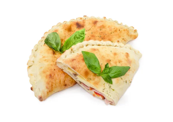 One whole and half of cooked calzone with basil twigs — Stock Photo, Image