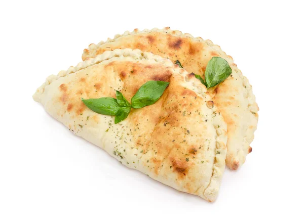 Dos calzone cocidos con ramitas de albahaca sobre un fondo blanco — Foto de Stock