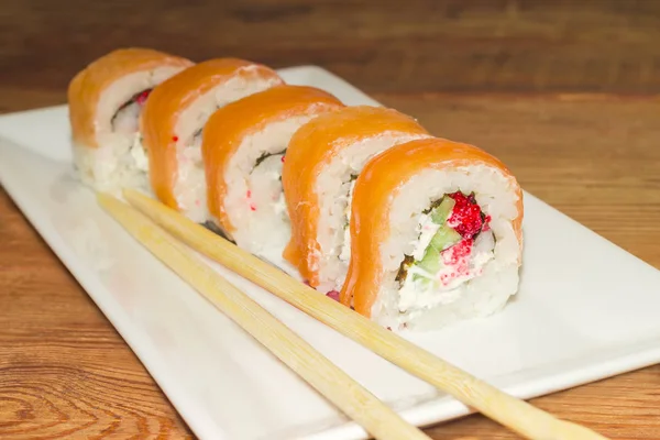 Sushi con salmón con palillos en plato rectangular de primer plano —  Fotos de Stock