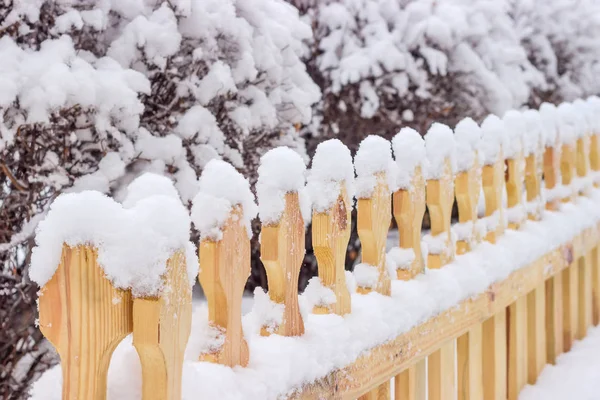 Decoratieve houten hek bedekt met sneeuw — Stockfoto