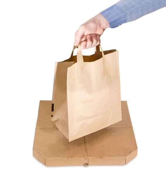 Papperspåse för matleveranser i hand över pizza box — Stockfoto