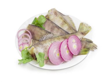 Otlar ve soğan ile beyaz bir yemek üzerinde çiğ notothenia