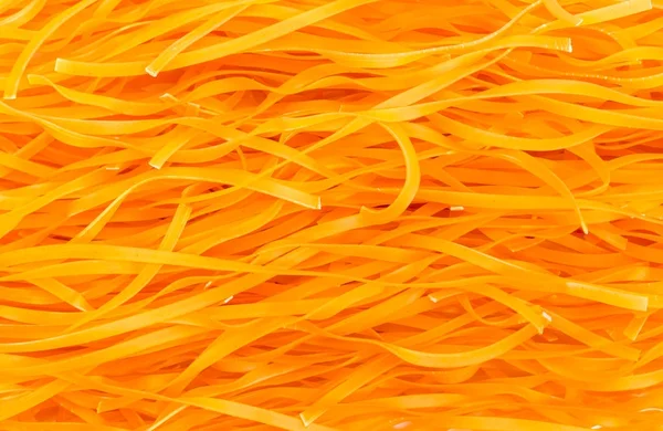 Background of uncooked orange noodles with paprika — Stock Photo, Image