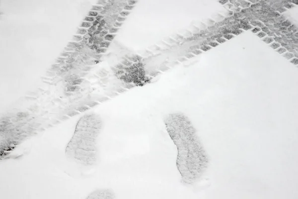 タイヤや靴底雪の上の足跡の痕跡 — ストック写真