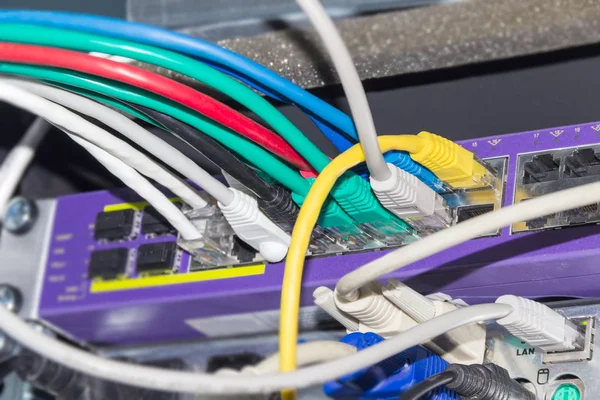 Multi-colored cables connected to equipment in telecommunication