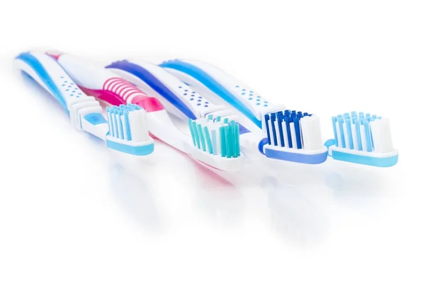 Escovas de dentes em uma superfície fosca branca close-up — Fotografia de Stock