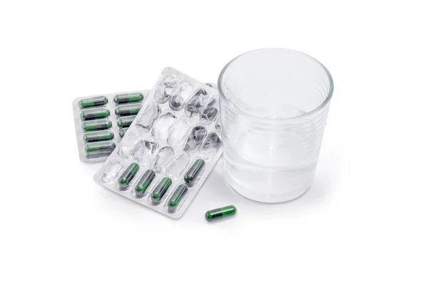 Envases blíster con suplementos dietéticos y vaso de agua — Foto de Stock