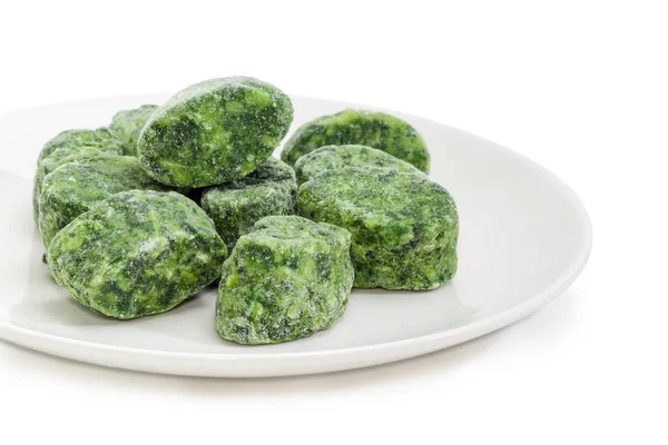 Cubes of chopped and frozen spinach on white dish closeup — Stock Photo, Image