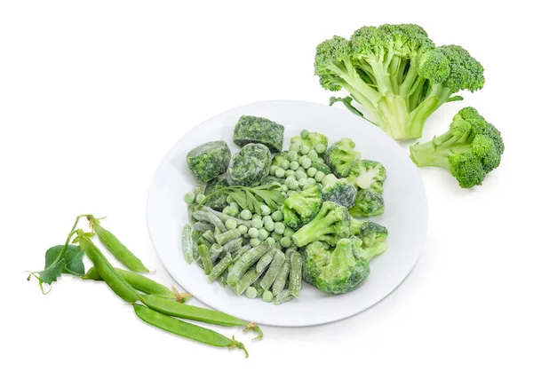 Diferentes verduras verdes congeladas y frescas sobre un fondo blanco — Foto de Stock