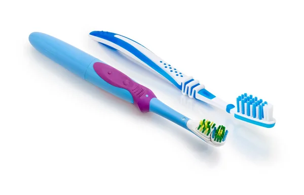 Escovas de dentes elétricas e convencionais em uma superfície fosca branca — Fotografia de Stock
