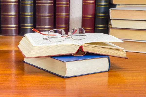 Eyeglasses on the two books against of other books — Stock Photo, Image