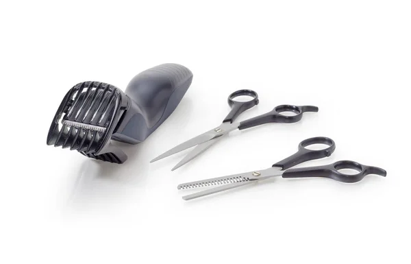 Two pairs of different hairdressers scissors and electric hair cclipper — Stock Photo, Image
