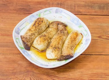 Pişmiş Eringi mantar yemeği rustik ahşap masa üzerinde