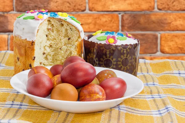 Два пасхальных торта и пасхальные яйца на клетчатой скатерти крупным планом — стоковое фото