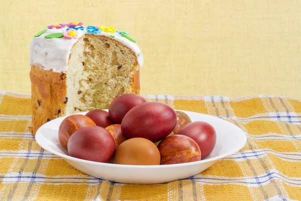 Corte parcialmente o bolo de Páscoa e os ovos de Páscoa na toalha de mesa quadriculada — Fotografia de Stock