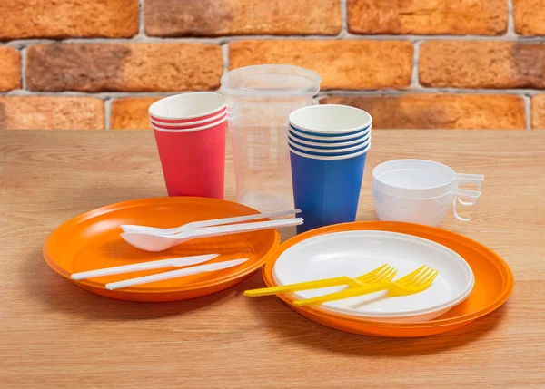 Different disposable cutlery on a wooden table — Stock Photo, Image