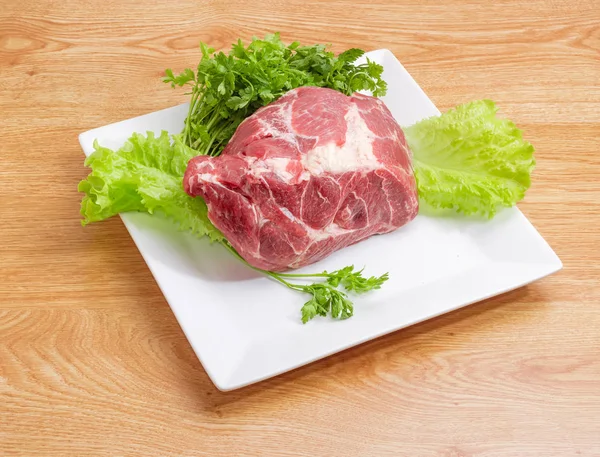角皿に緑と調理の豚肉の首の部分 — ストック写真