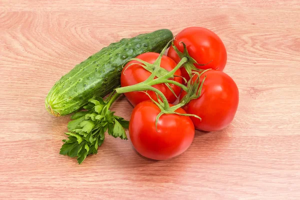 Tomates sur branche, concombre et persil sur une surface en bois — Photo