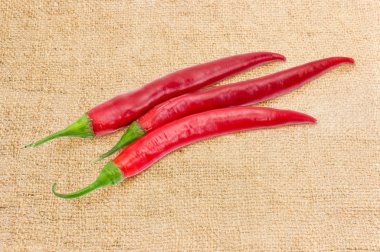 Bir çuval bezi üzerinde üç kırmızı biber biber