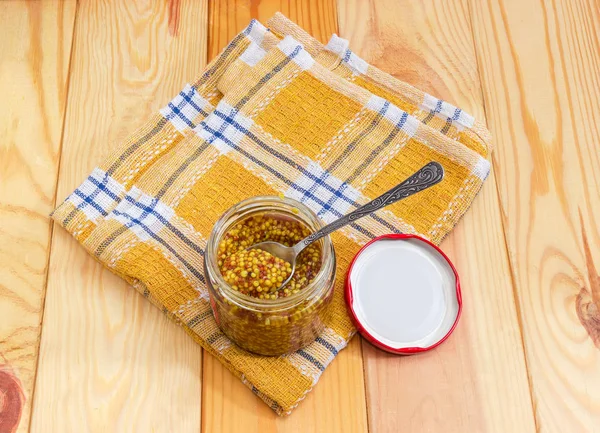 Moutarde française dans un petit bocal en verre avec cuillère sur serviette — Photo