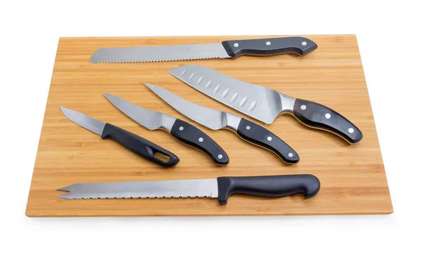 Várias facas de cozinha diferentes na placa de corte de bambu — Fotografia de Stock