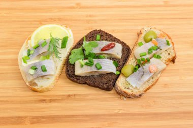 Üç farklı sandviç kesme tahtası üzerinde salamura ringa balığı ile açın