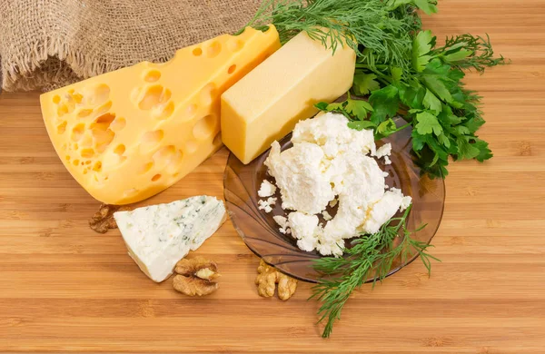 Vários queijo e queijo cottage na placa de corte de bambu — Fotografia de Stock