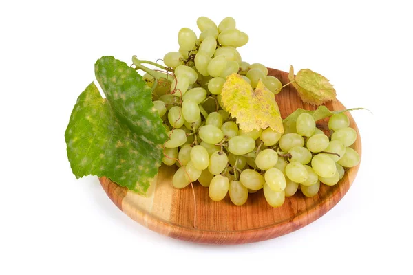 Racimo de uva Sultana con hojas de vid en plato de madera vintage — Foto de Stock