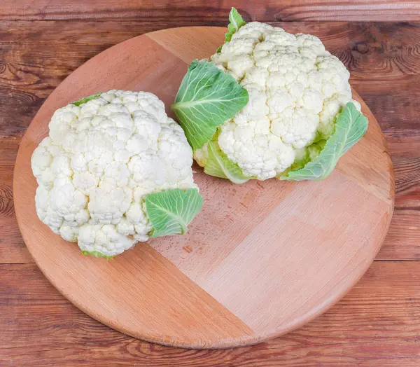 Two fresh cauliflower heads on the wooden serving board — Stock Photo, Image