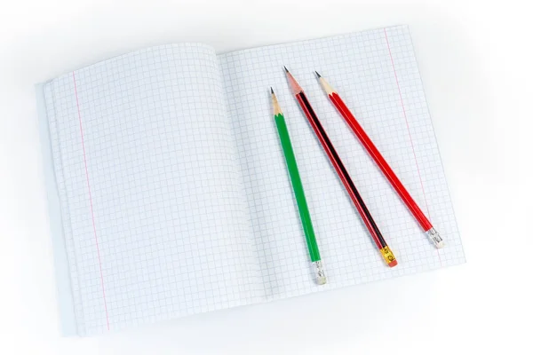Diferentes lápis de grafite colocados no caderno de exercícios aberto, vista superior — Fotografia de Stock
