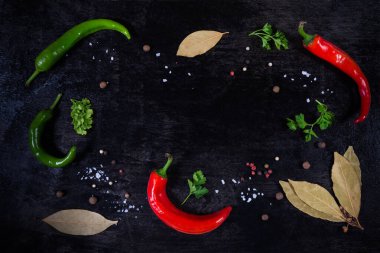 Çeşitli baharatlar ve sebzelerle dolu siyah bir zemin.