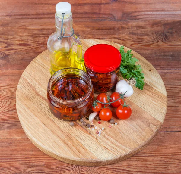 Tomates séchées dans l'huile d'olive dans des bocaux en verre parmi les ingrédients — Photo