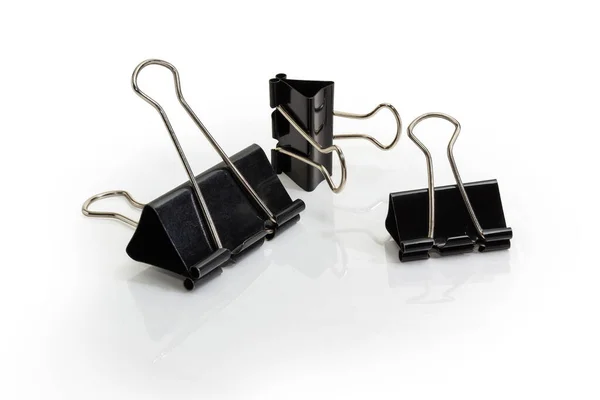 Paper binder clips different sizes on a white background — Stock Photo, Image