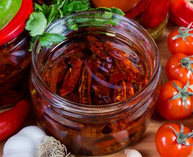 Taze sebzelerin arasında zeytinyağında kurutulmuş domates kavanozu