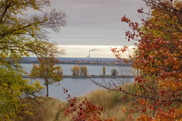 Árvores com folhas de outono na colina sobre o reservatório — Fotografia de Stock