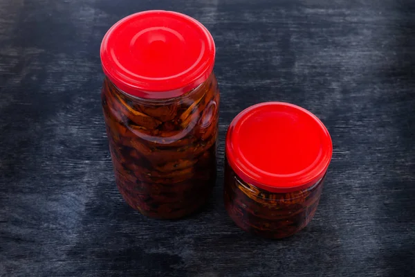 Tomates secos conservados en aceite de oliva en dos frascos de vidrio —  Fotos de Stock