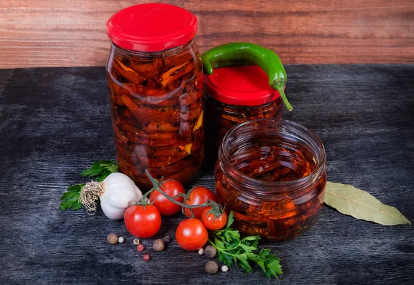 Sundried tomatoes in olive oil in glass jars among ingredients — Stock Photo, Image