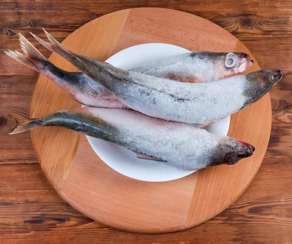 Top vista congelado peixe Redbait no prato na mesa rústica — Fotografia de Stock