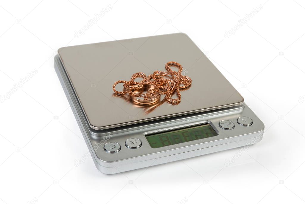 Professional digital table scales and gold jewelry on them close-up