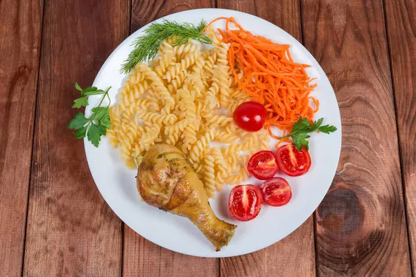 Gamba di pollo alla griglia con pasta a spirale cotta, verdure, vista dall'alto — Foto Stock