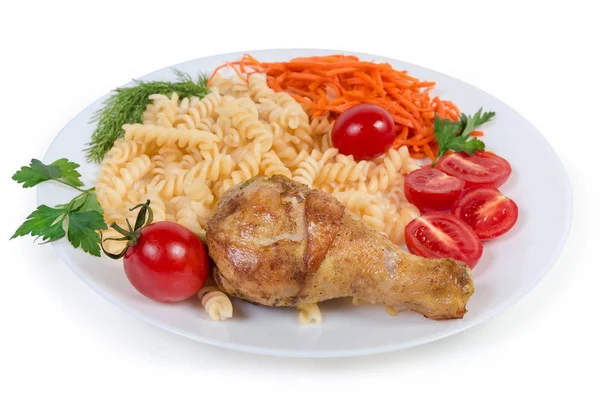 Fried chicken leg with cooked spiral pasta, vegetables close-up — Stock Photo, Image