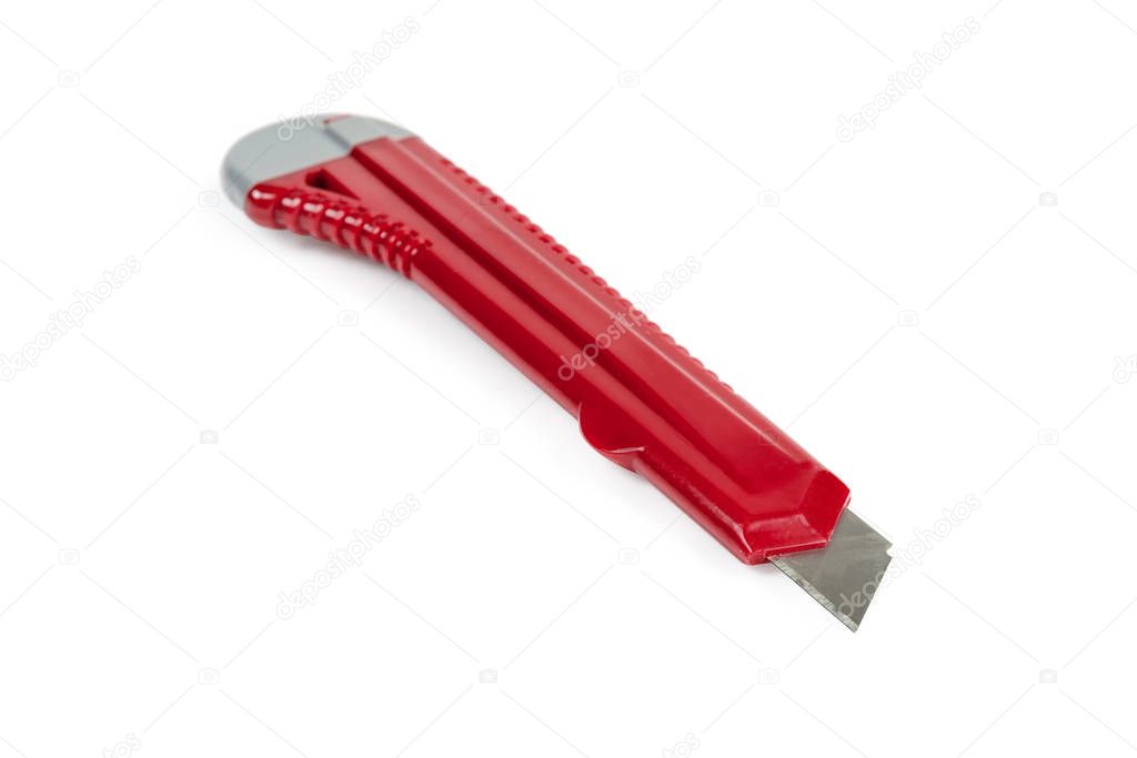 Red stationery cutter knife close-up on a white background