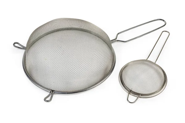 Two inverted round stainless steel sieve on a white background — 图库照片
