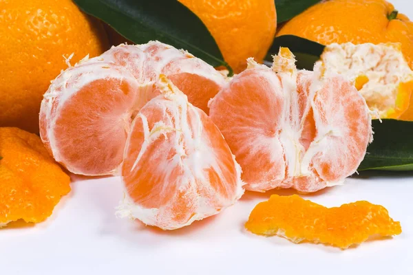 Mandarine pelée divisée en segments contre les autres mandarines — Photo