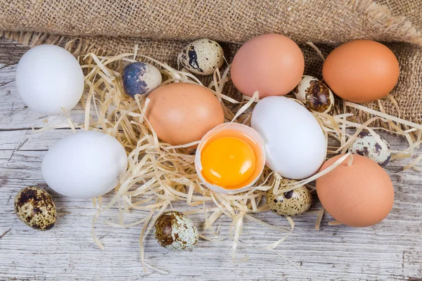 Vařené kuřecí a křepelčí vejce na starém dřevěném povrchu — Stock fotografie