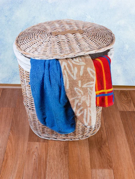 Cesta de ropa de mimbre de madera en el suelo y toallas de baño — Foto de Stock