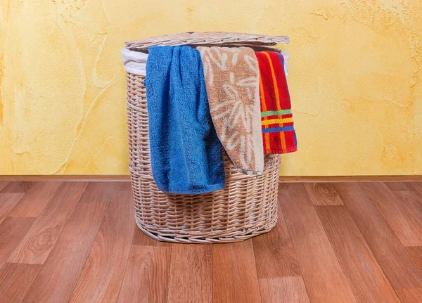 तल और स्नान तौलिए पर लकड़ी विकर कपड़े धोने की टोकरी — स्टॉक फ़ोटो, इमेज